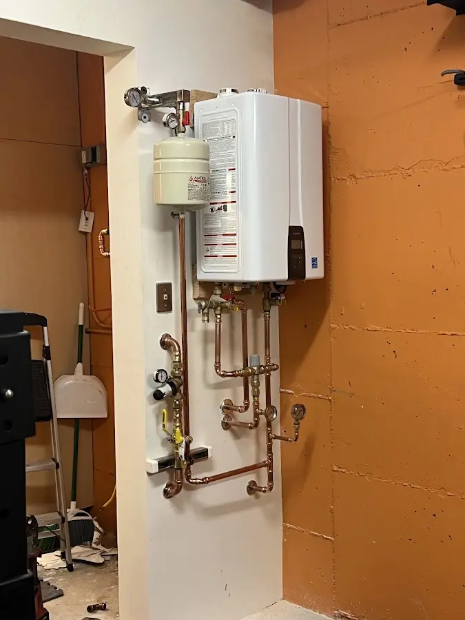 Plumbing technician inspecting water heater connections in Forrest City